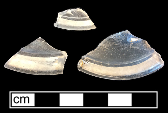 Colorless leaded glass wine glass folded foot fragments. 2.5” diameter. Folded feet most likely provided protection against chipping.  They were common until around 1730-1740 (Bickerton 1986:34). 18CV60